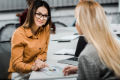 young businesswomen meeting with papers and laptop at workplace in office