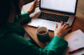 business woman with coffee cup working on laptop at desk