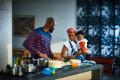 Young African American family with baby cooking together in kitchen