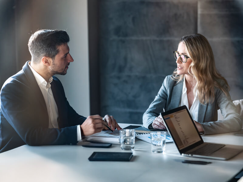 seated businessman and woman talking