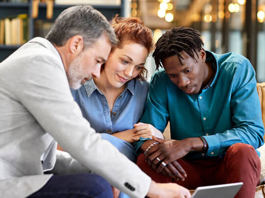 3 people working together looking at laptop screen